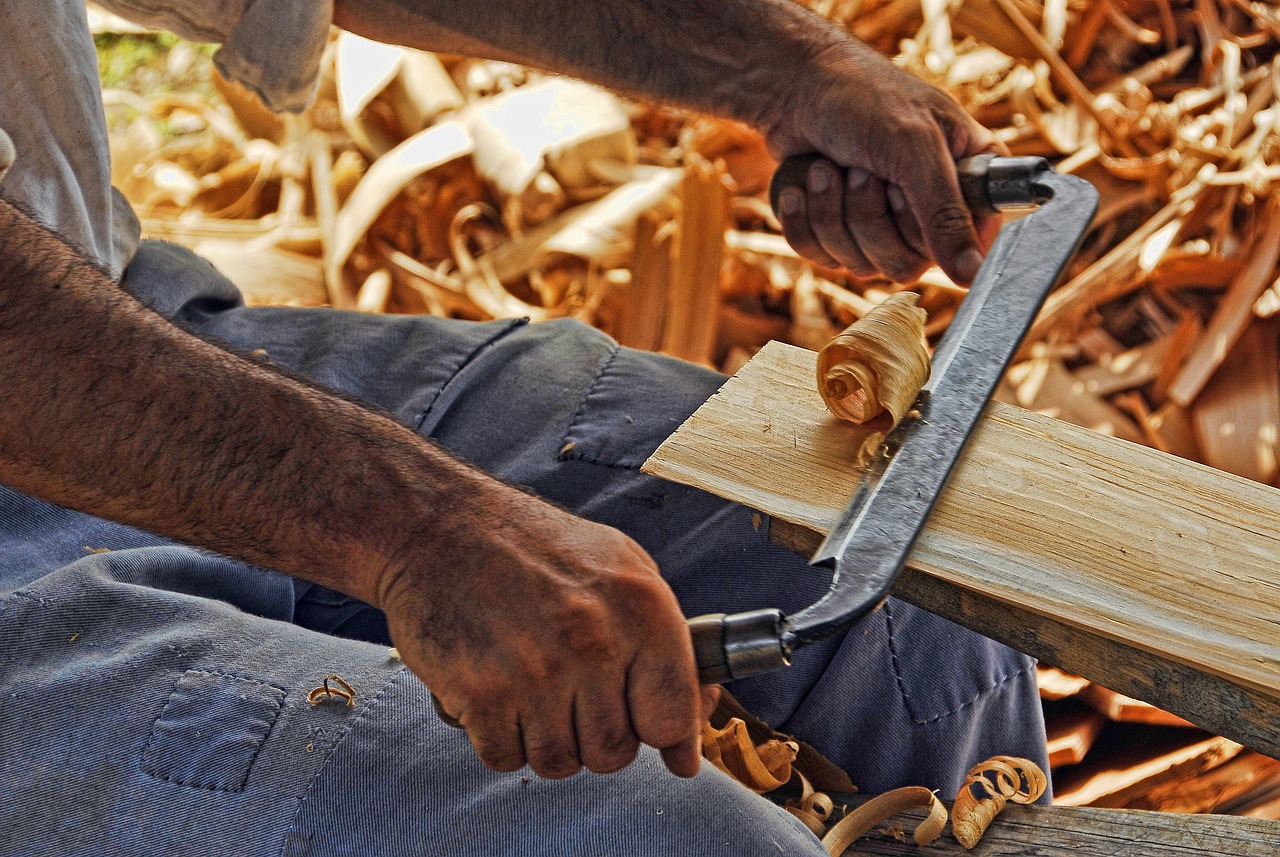 Hands shaving timber